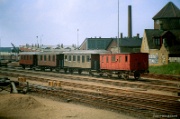 Odense war bis 1966 Ausgangspunkt mehrerer Privatbahnen, von denen hier ein paar Personenwagen zu sehen sind, die  mit Hilfe aus dem Forum von jernbanen.dk als (von links) OKMJ A 10-OKMJ A 11-OKMJ C 9-NFJ D 31 identifiziert werden konnten. Eigentlich zum Verschrotten verkauft, blieben alle erhalten. NFJ D 31 wurde 1882 in Breslau gebaut, OKMJ C 9 im Jahr 1911 in Arl�v (Schonen), die beiden anderen 1914 von Scandia in Randers. : D�nemark, DNK, Odense, Odense C